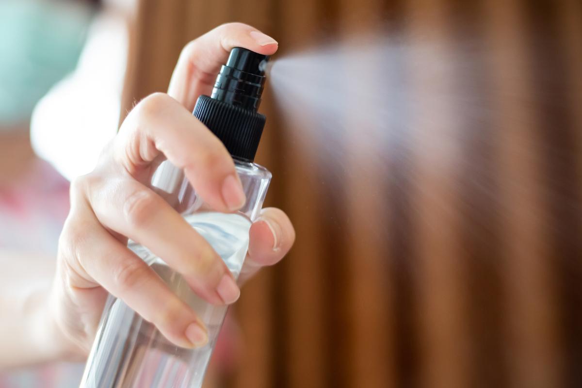 Persona che spruzza l'alcol sul materasso
