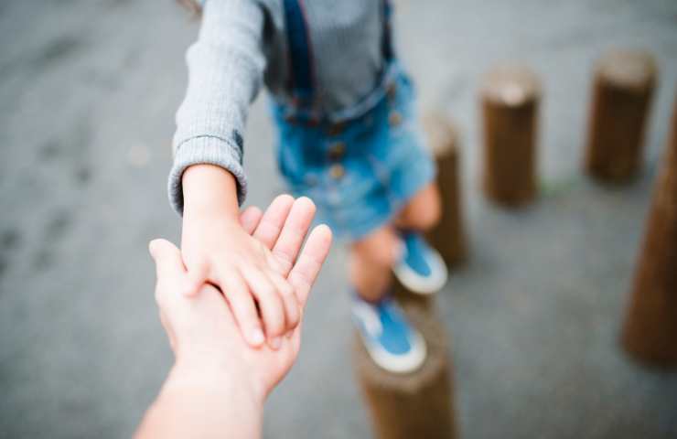 adulto tiene per mano bambino che gioca