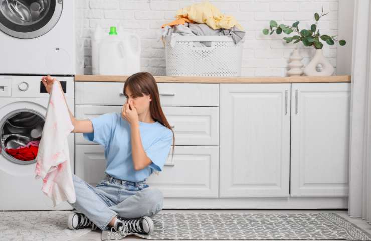 ragazza si tappa il naso per bucato puzzolente
